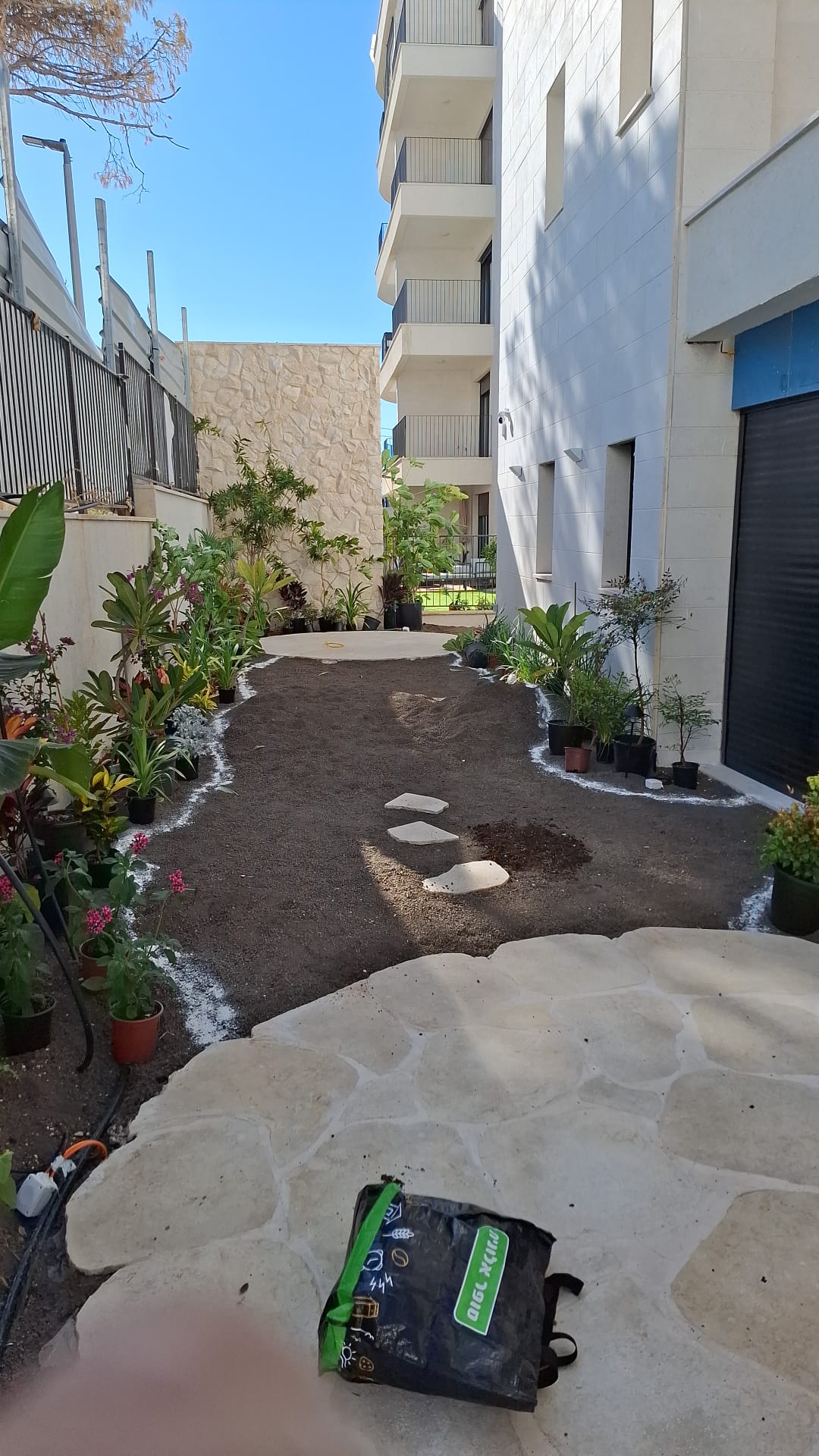 הנוף אחרי — ערוגות מעוצבות ושביל אבן